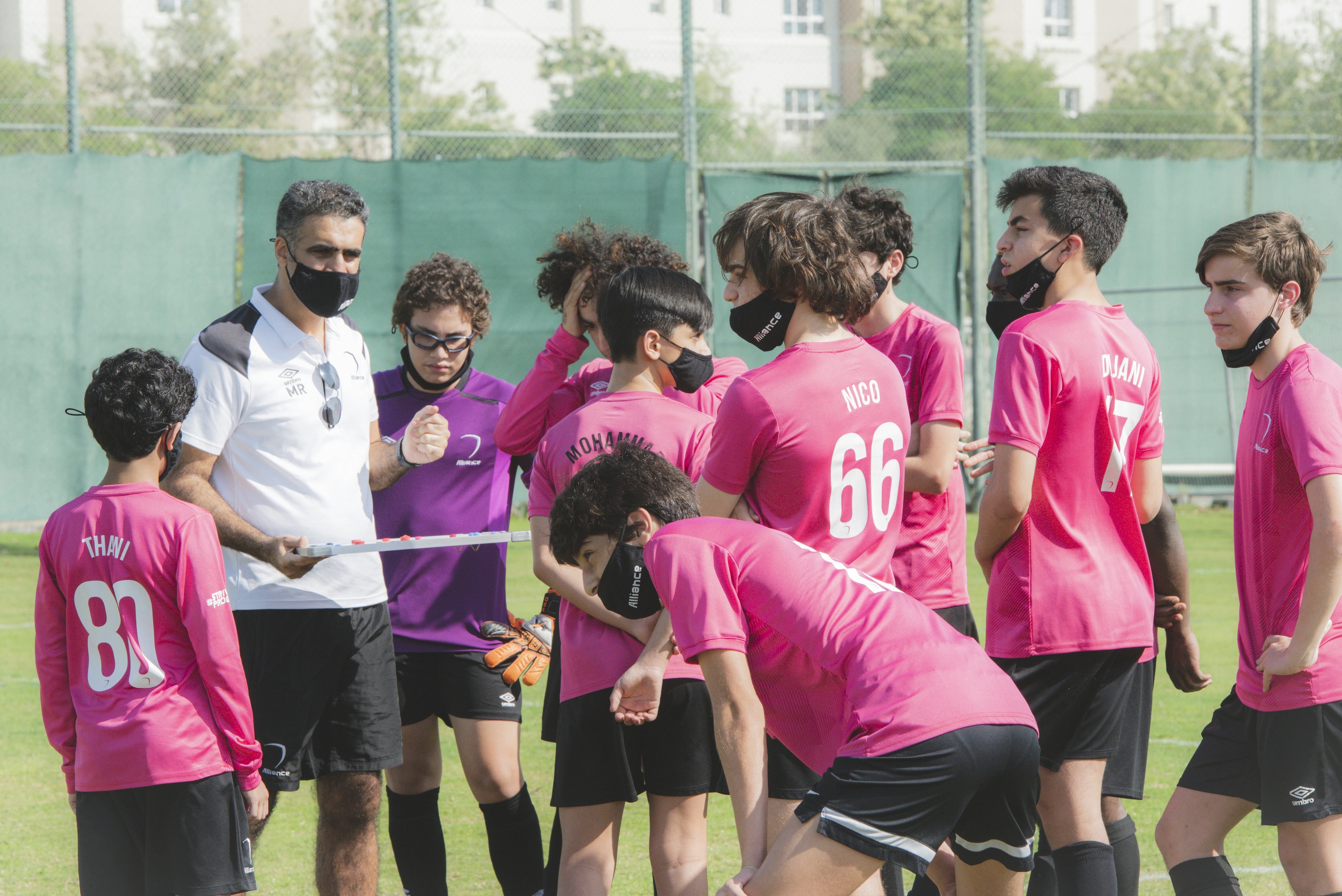 Group of fitness coaches in purple and white team shirts