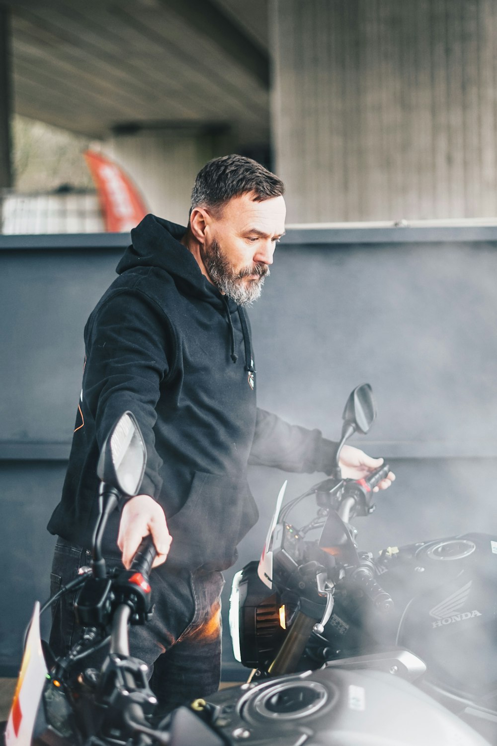 man in black jacket holding bicycle