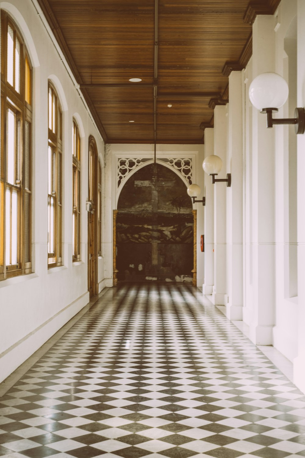 white and black hallway with brown wooden door
