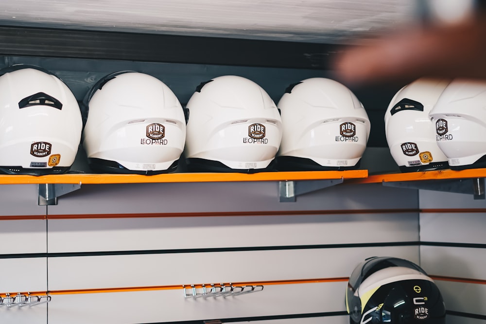 white and black helmet on brown wooden shelf