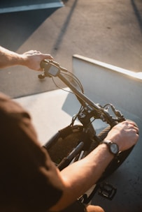Wrist brace worn by a cyclist gripping handlebars on a sunny trail