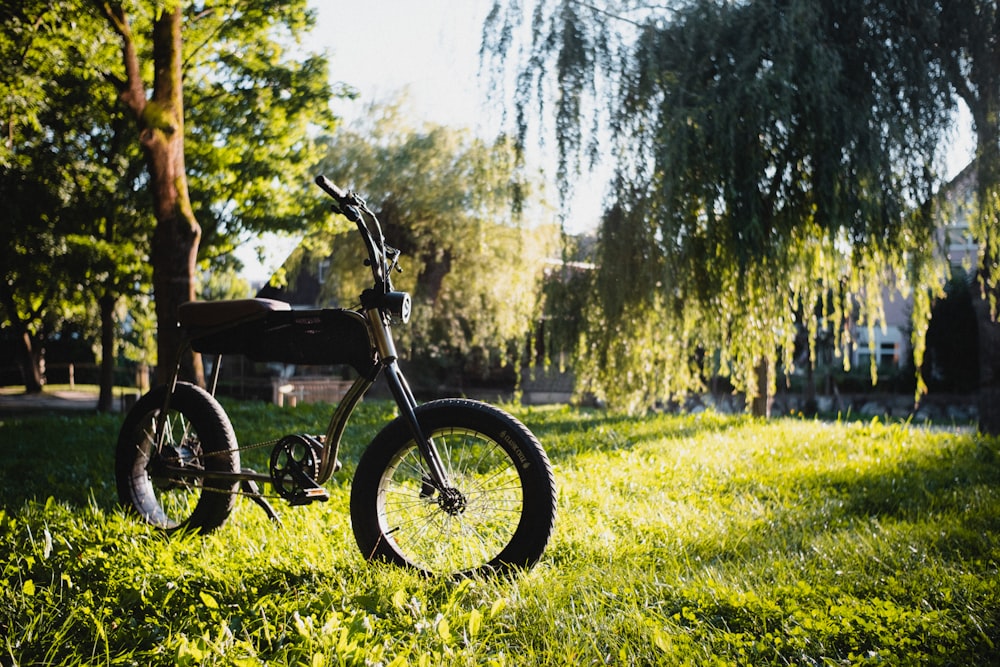 낮 동안 푸른 잔디밭에 검은 색과 회색 오토바이