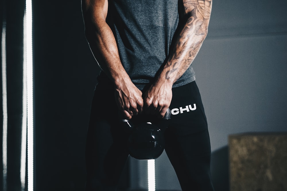 man in black tank top and black pants