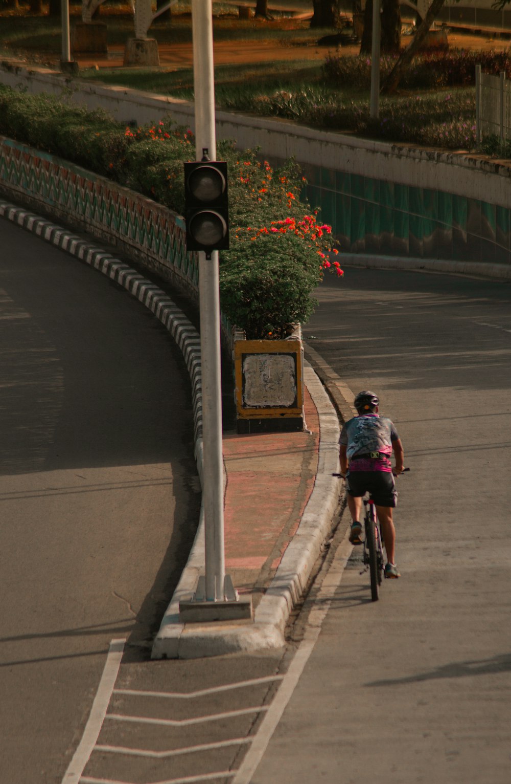 man in red shirt riding bicycle on road during daytime