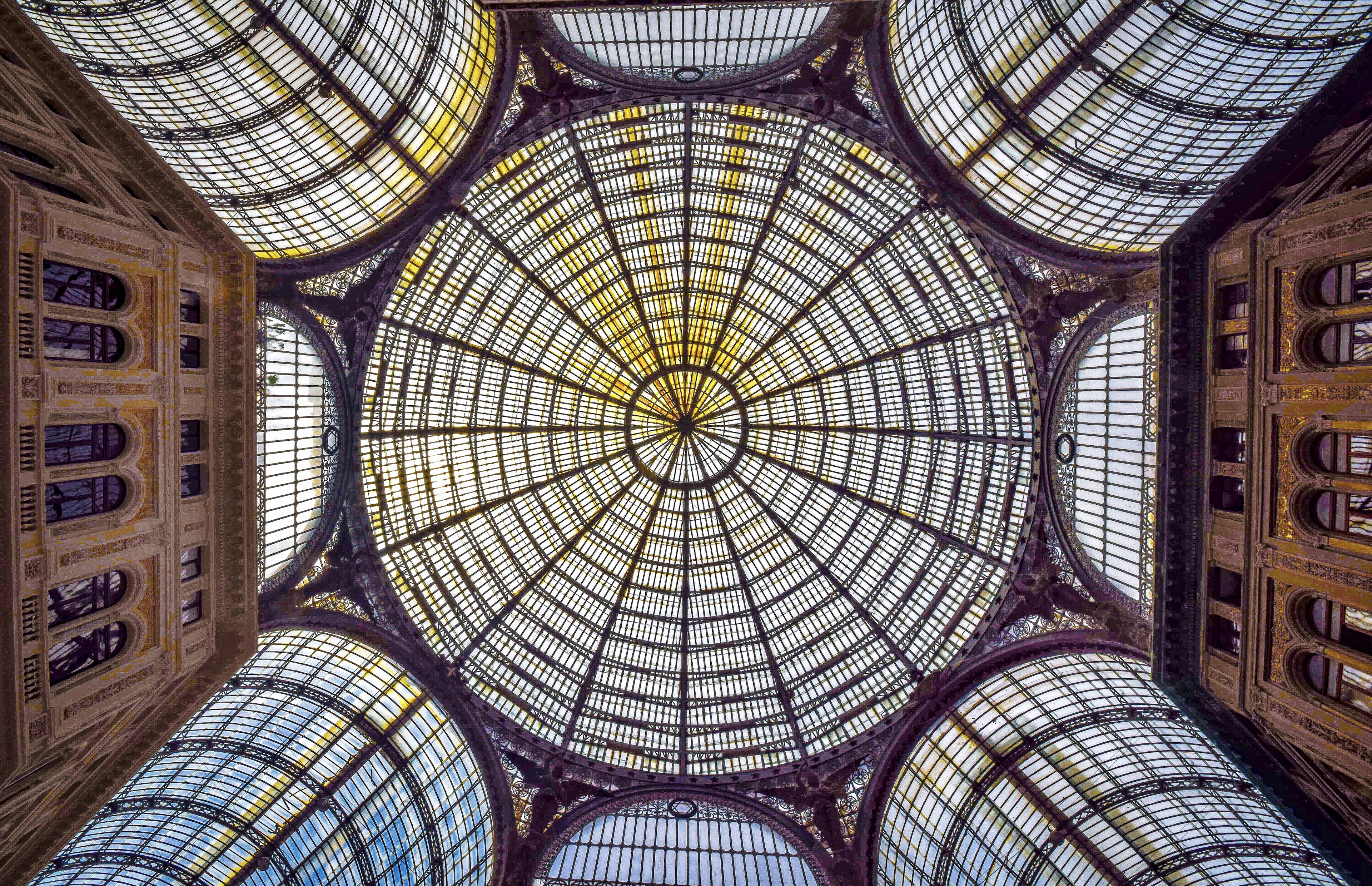 The glass-and-iron dome of the Galleria Umberto I in Naples, photographed straight up from the floor of the arcade.