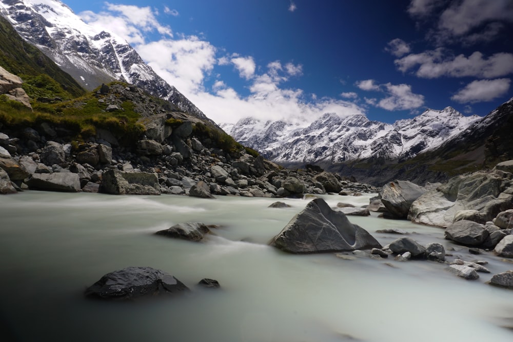 snow covered mountains near body of water during daytime