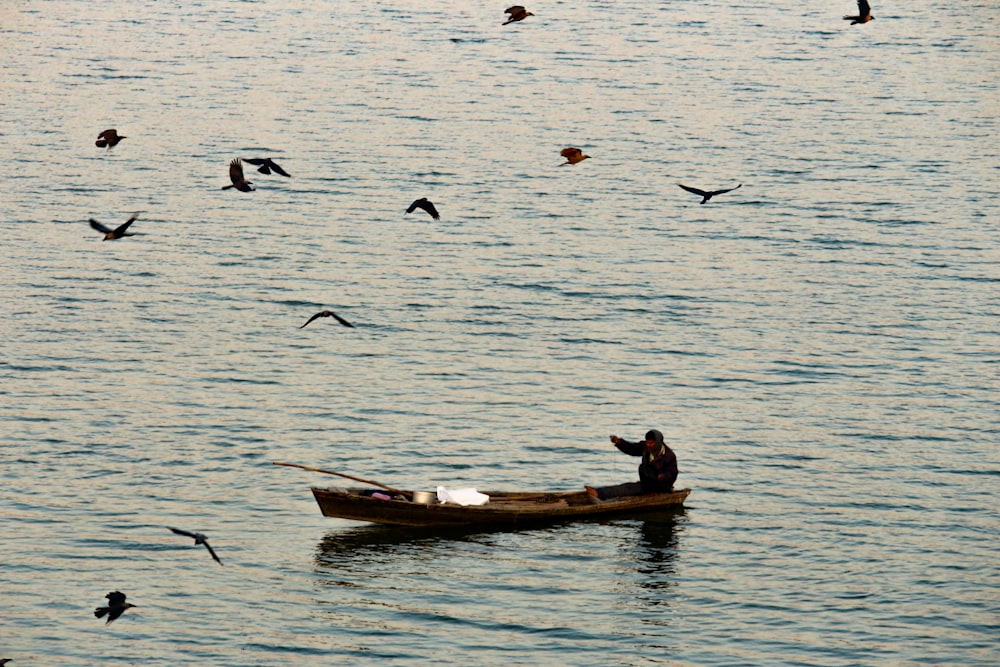 man and woman riding on brown boat on body of water during daytime