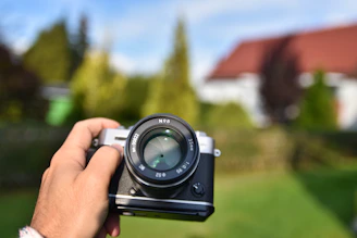 person holding black and silver camera