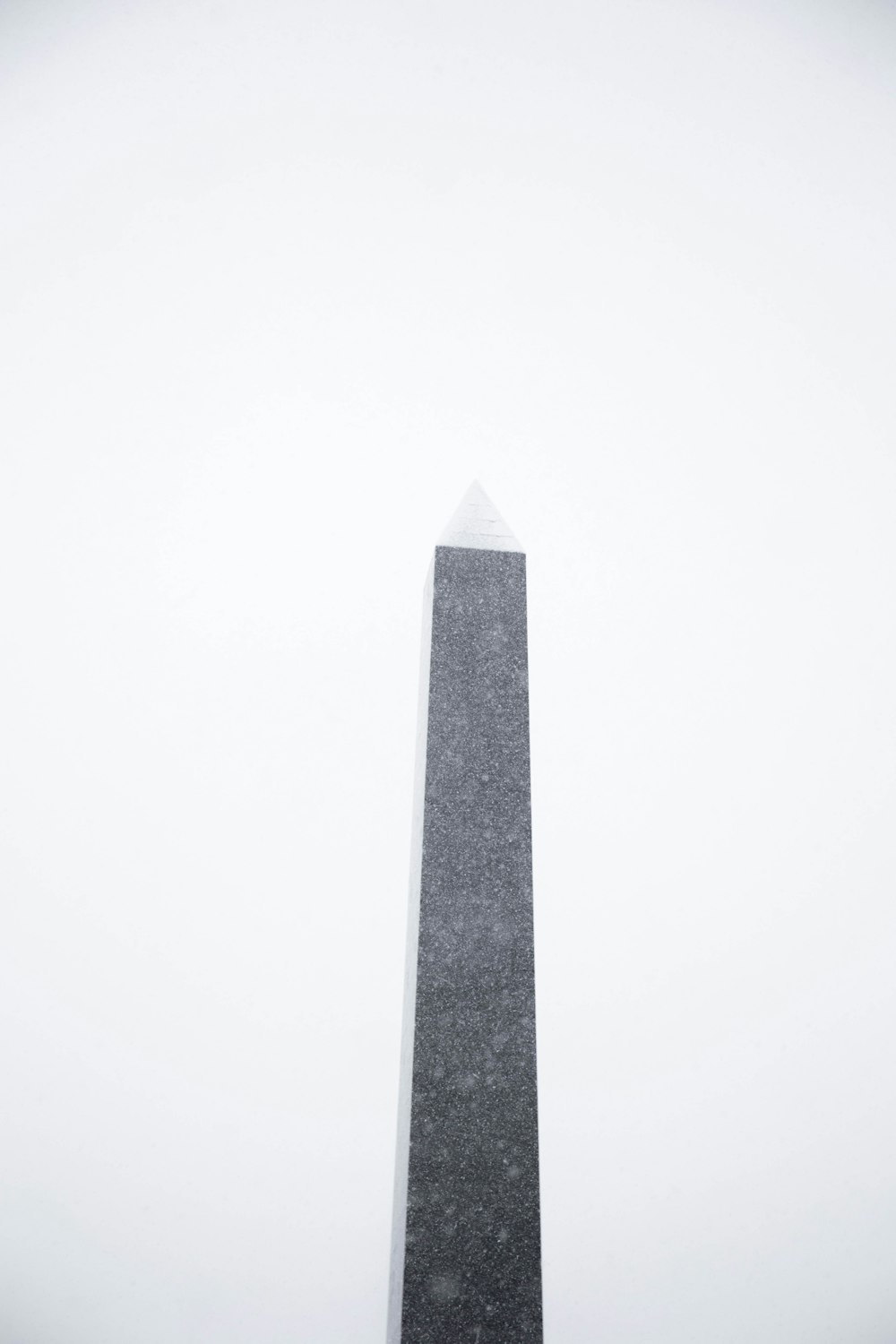 torre di cemento grigio sotto il cielo bianco