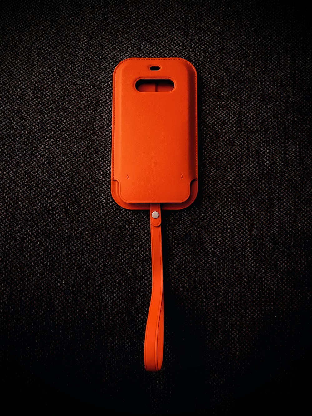 orange iphone case on black textile