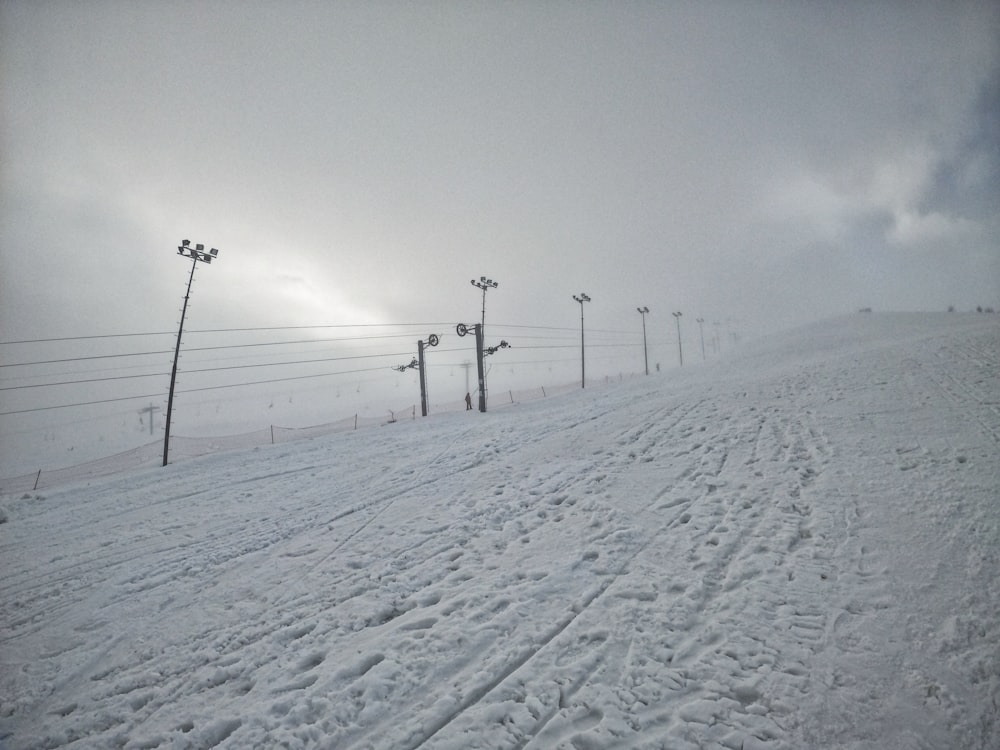 black electricity post on snow covered ground