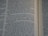 Close-up view of an open book showing text from a religious or historical scripture. The passage focuses on an instruction involving the behavior of men drinking water, emphasizing the separation based on how they drink.