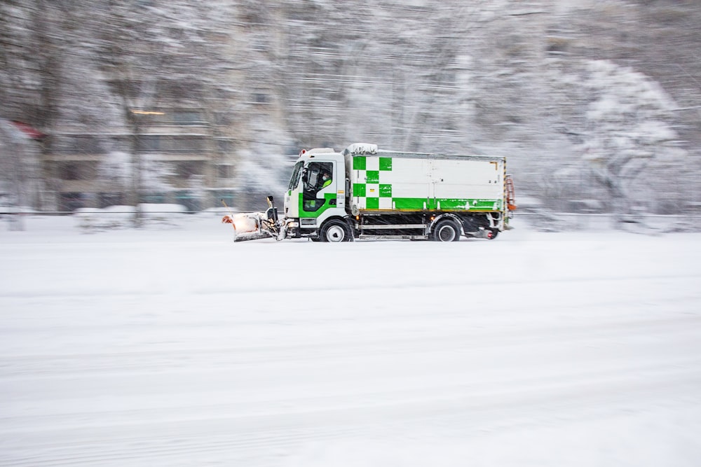 green truck on snow covered road during daytime