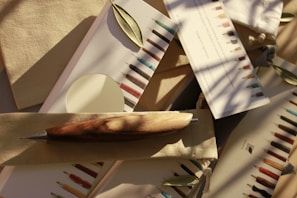 A close-up of colorful gel and fountain pens arranged neatly on a wooden desk.