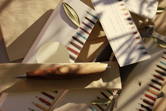 Set of elegant pens with rose and wine tones arranged on a neutral linen cloth