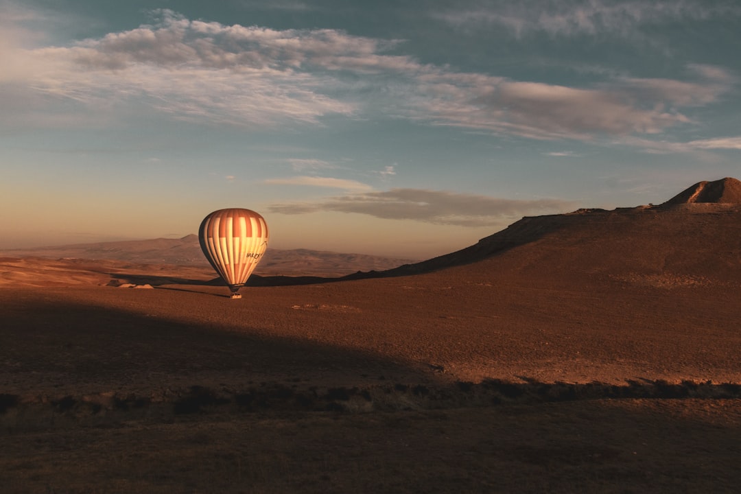 hot air balloon on brown field under blue sky during daytime