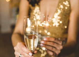 woman in white dress holding clear wine glass