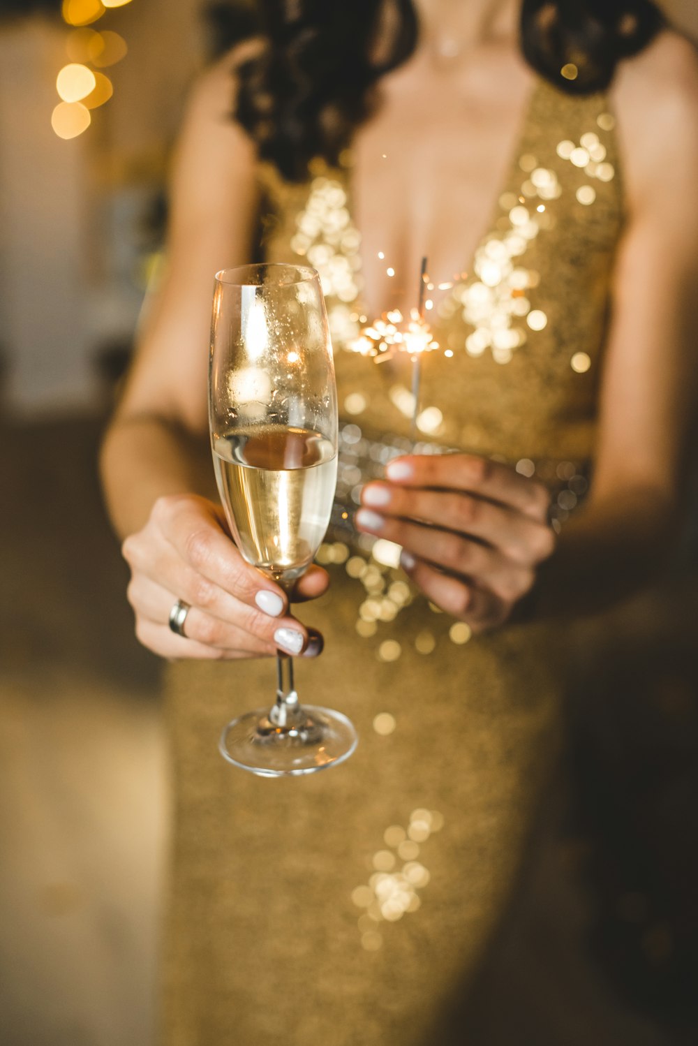 woman in white dress holding clear wine glass