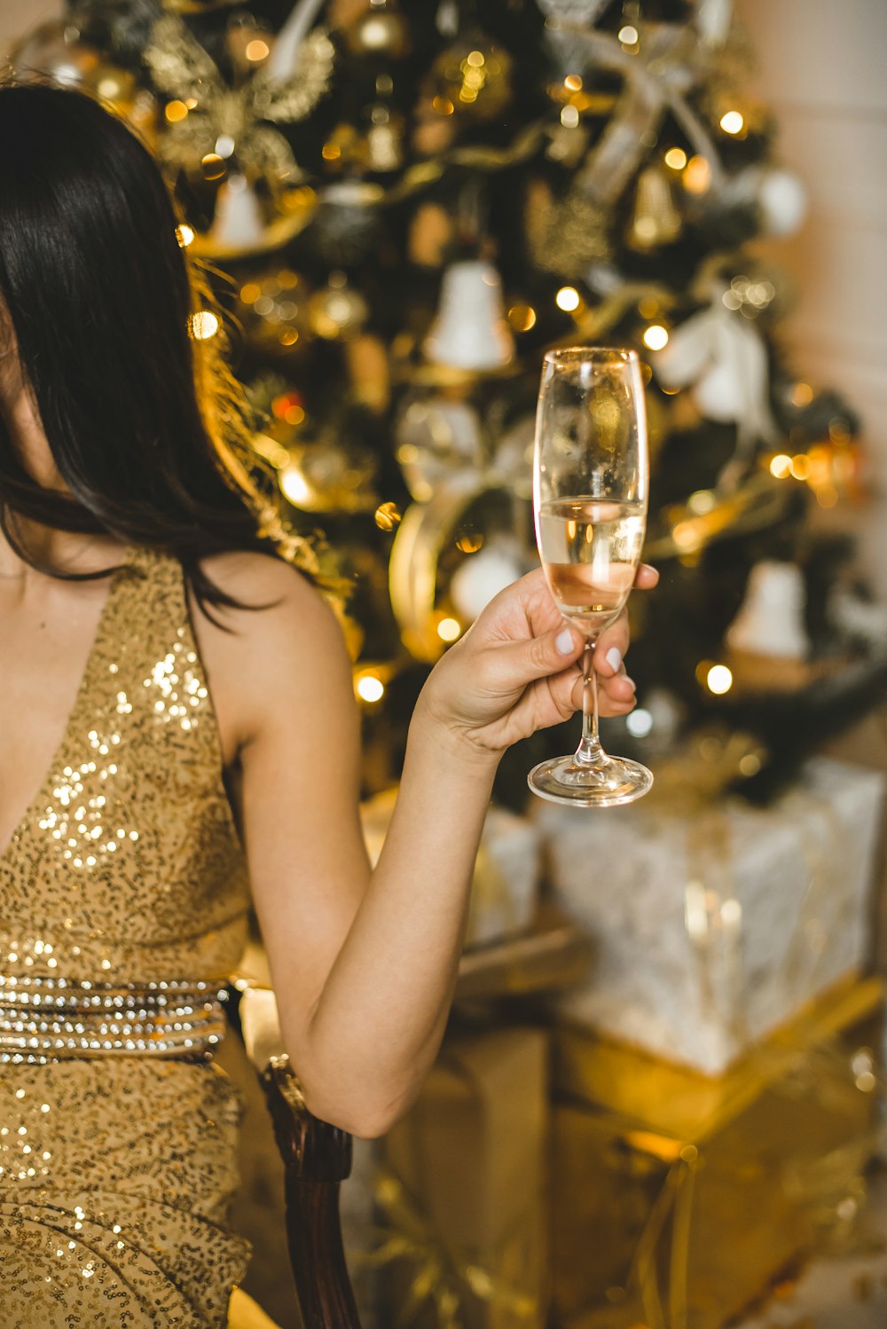 woman in brown sleeveless dress holding clear wine glass