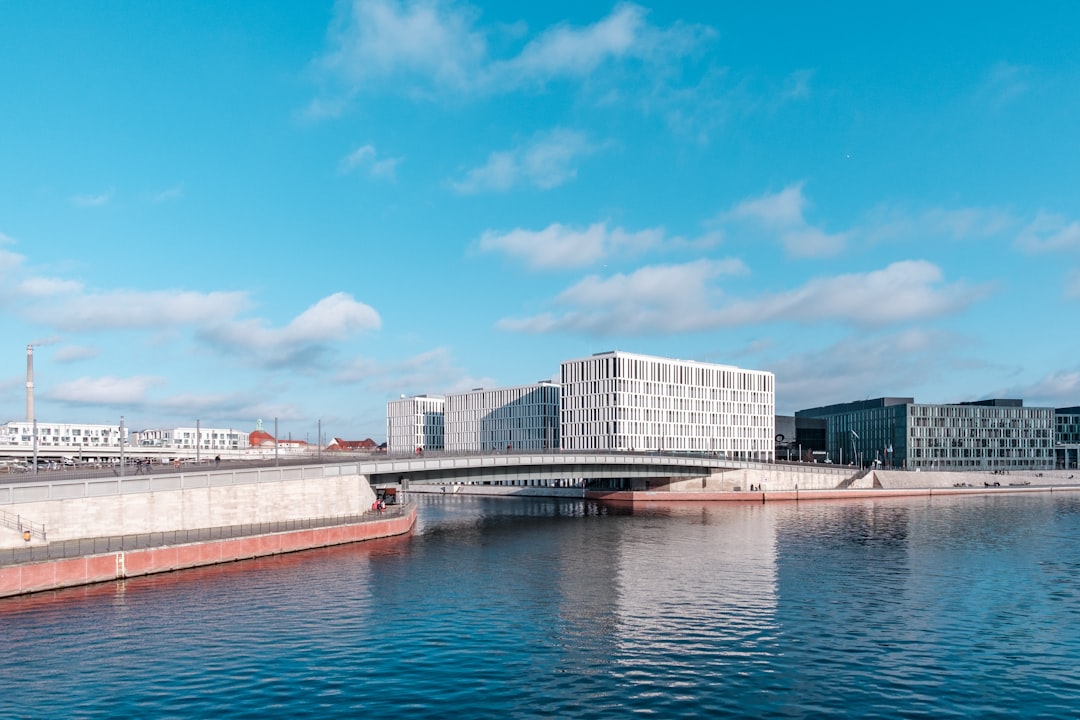 white and gray concrete building near body of water under blue sky during daytime