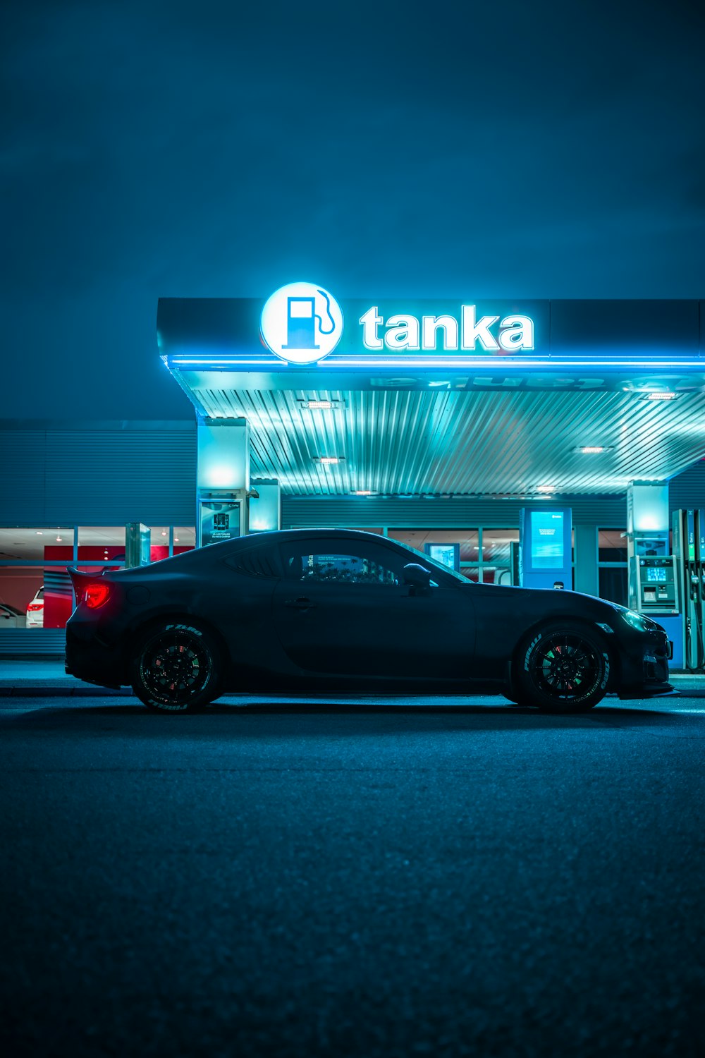 cupé negro estacionado frente a la tienda UNKs