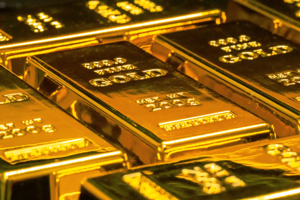 Stacked gold bars stamped 999.9 fine, lit in warm light