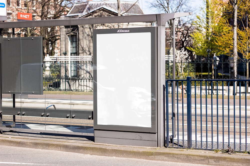 white board on black metal fence