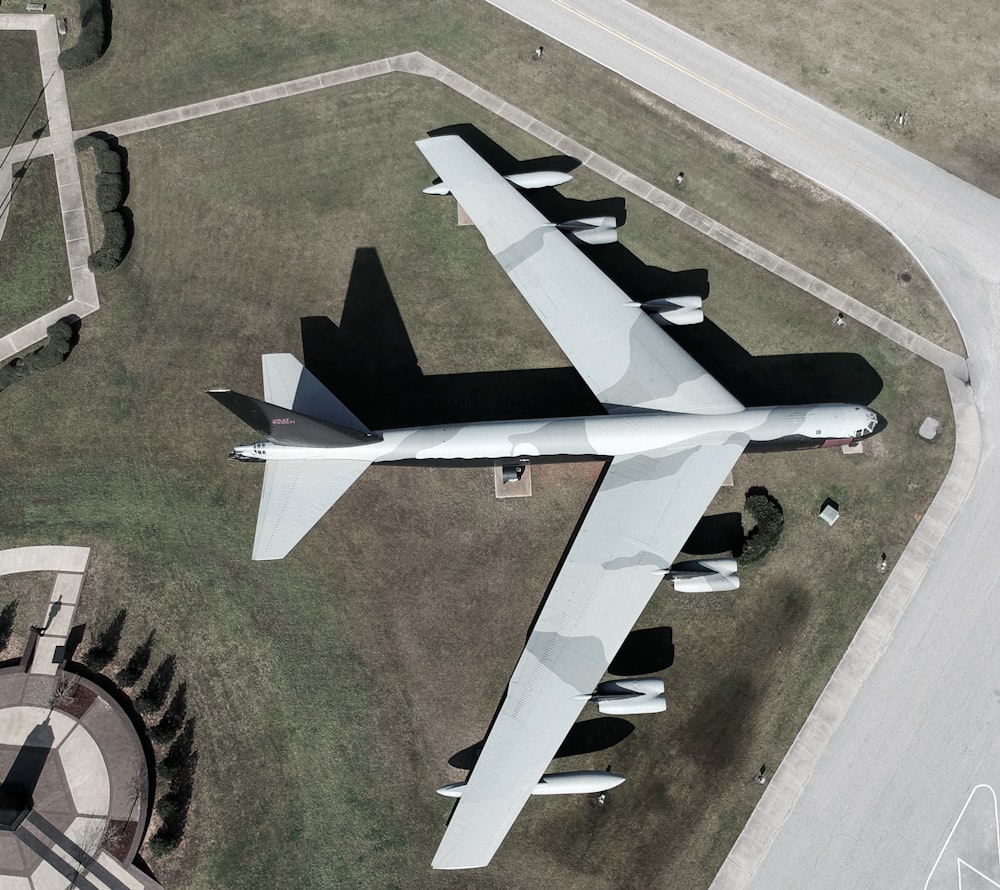 white and black jet plane on green grass field