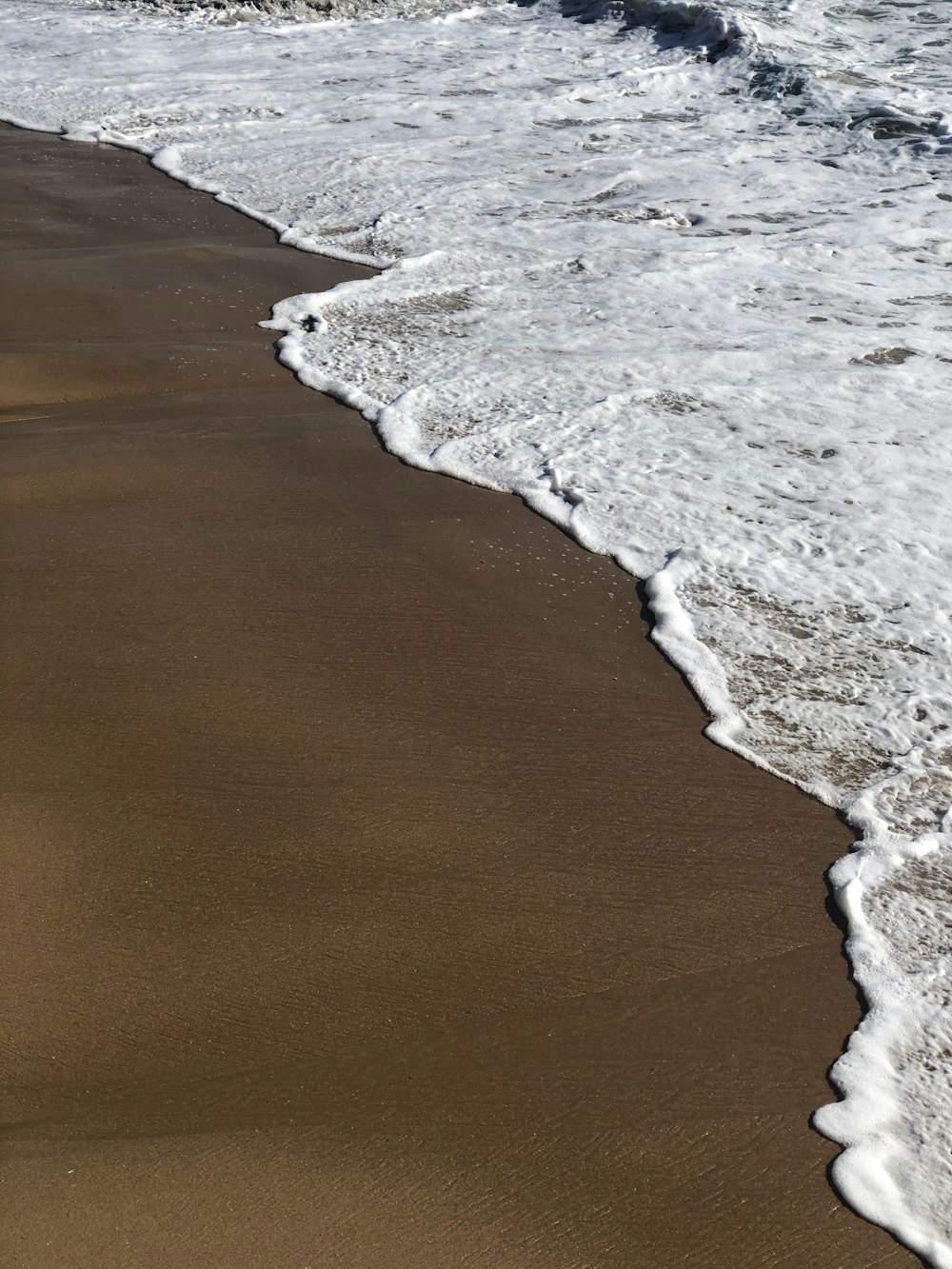 ocean waves crashing on shore during daytime