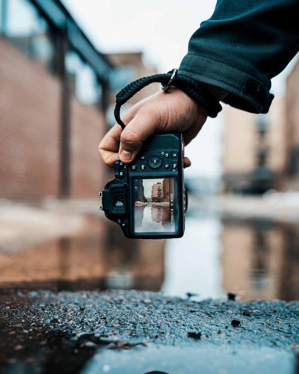 person holding black digital camera