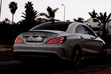 Red 2025 Mercedes C-Class AMG parked elegantly in a scenic Yvelines street.