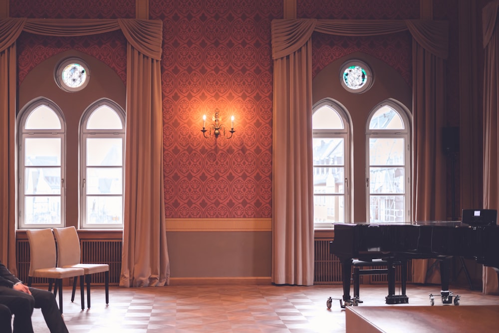 black grand piano near brown wooden door