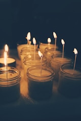 A collection of scented candles burning softly in a dimly lit room.