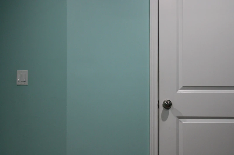 Crisp white door and trim beside a freshly painted sage green wall