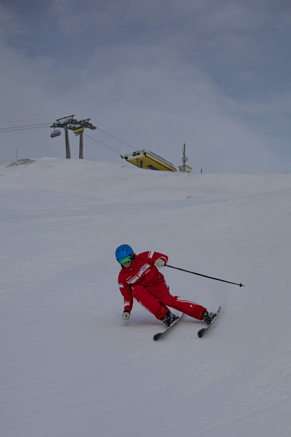 person in red jacket and blue pants riding on snow sled during daytime