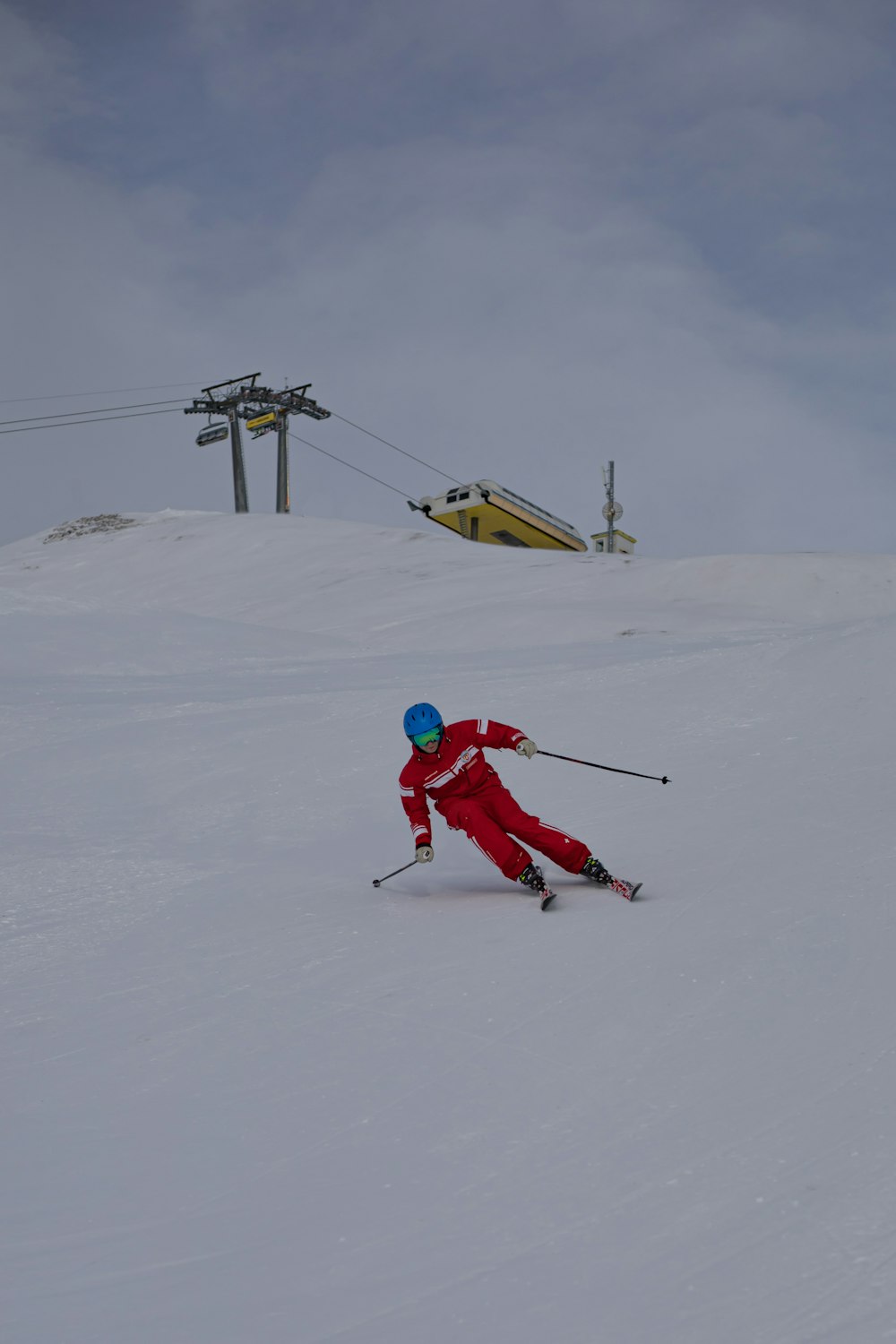 Persona con chaqueta roja y pantalones rojos montando esquí en la nieve