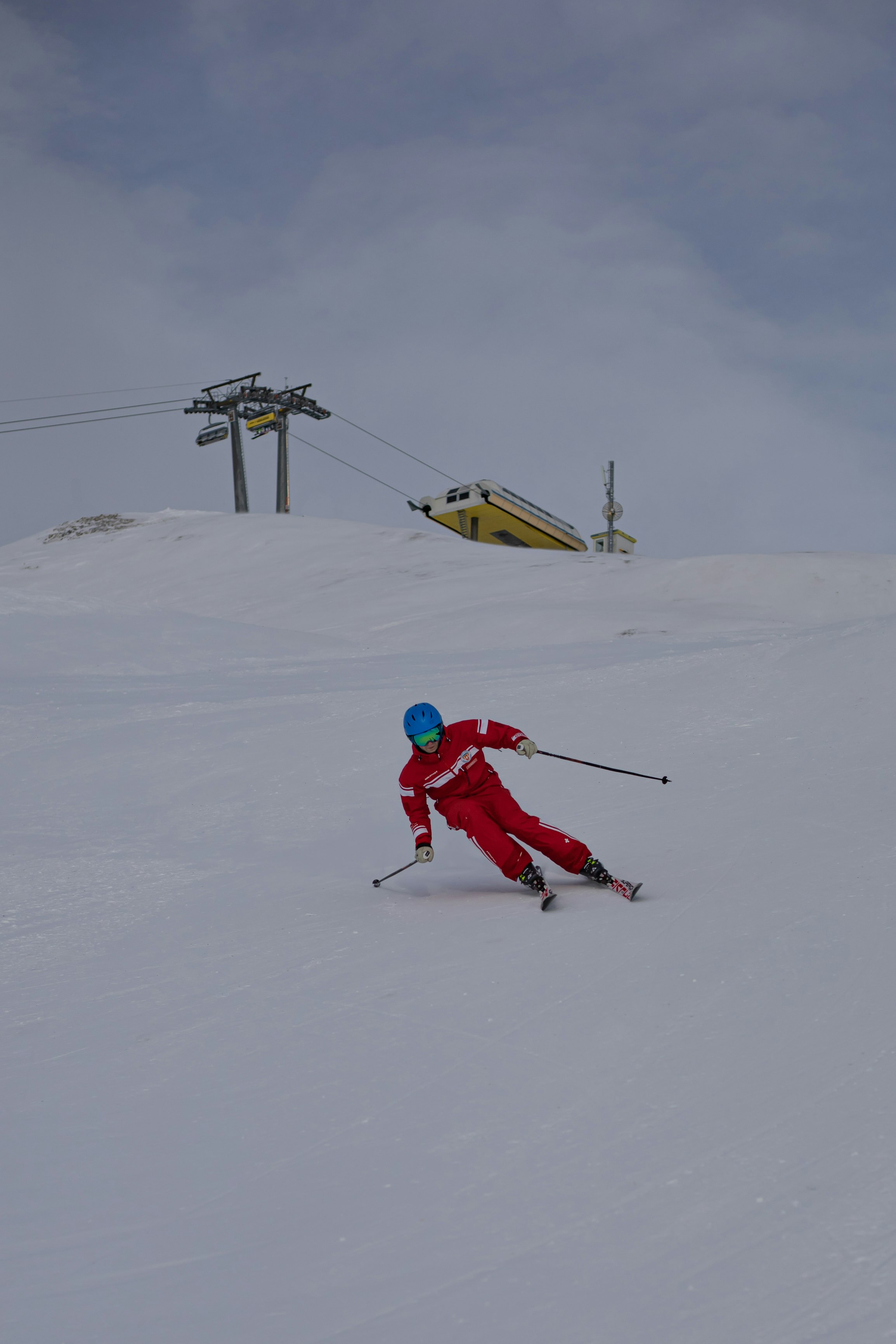 person in red jacket and red pants riding snow ski