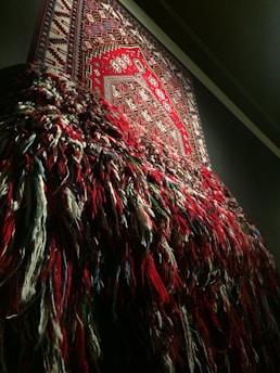 A colorful handwoven tapestry hanging on a rustic wall, showcasing intricate patterns