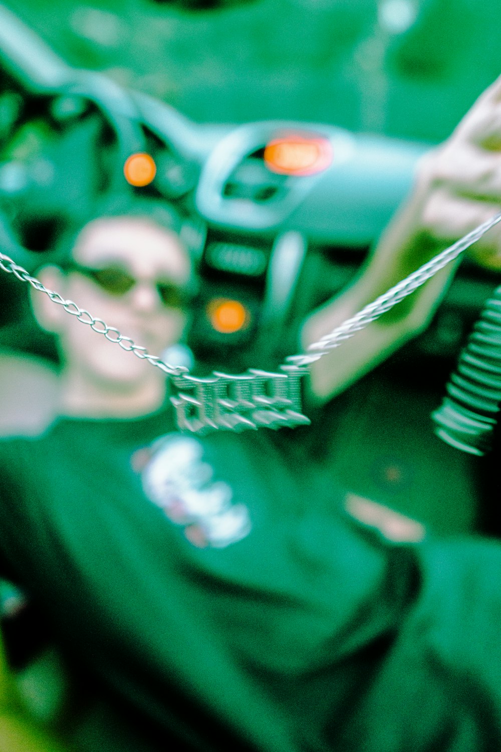 silver necklace on green car