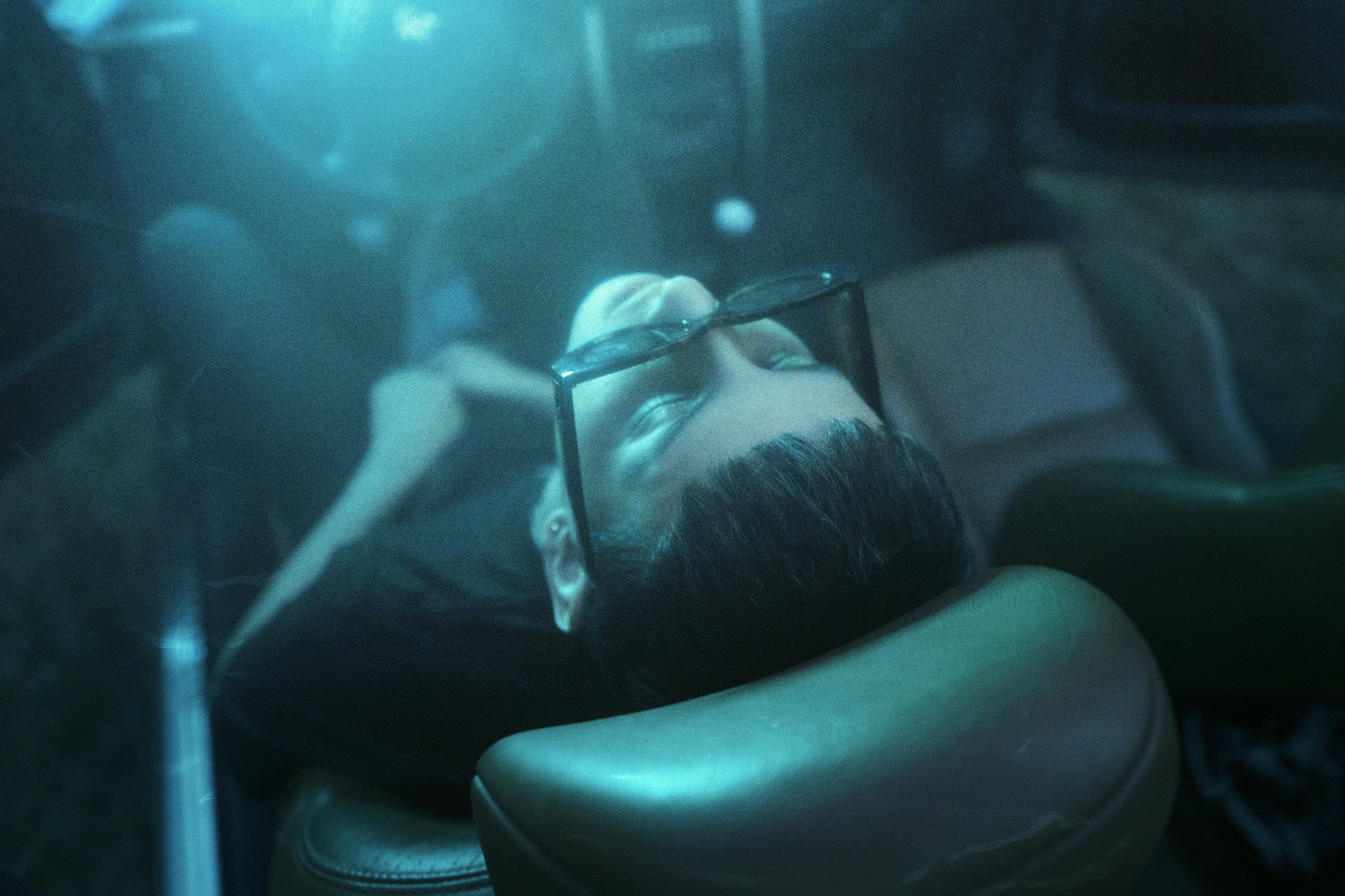 person lying on black leather sofa chair