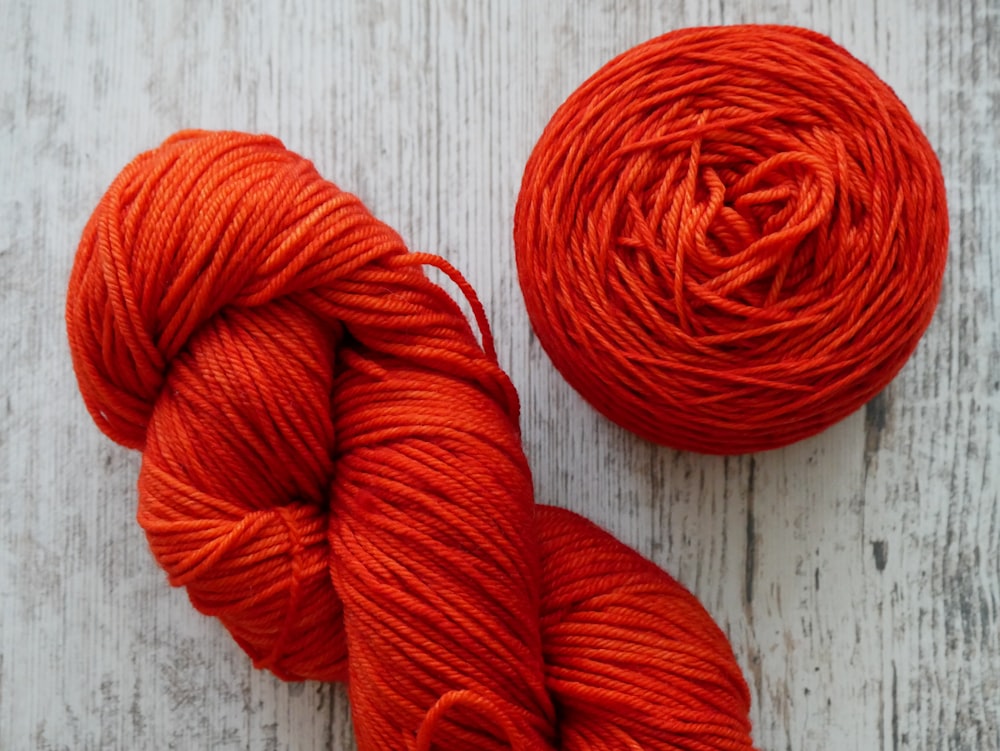 red yarn on brown wooden surface