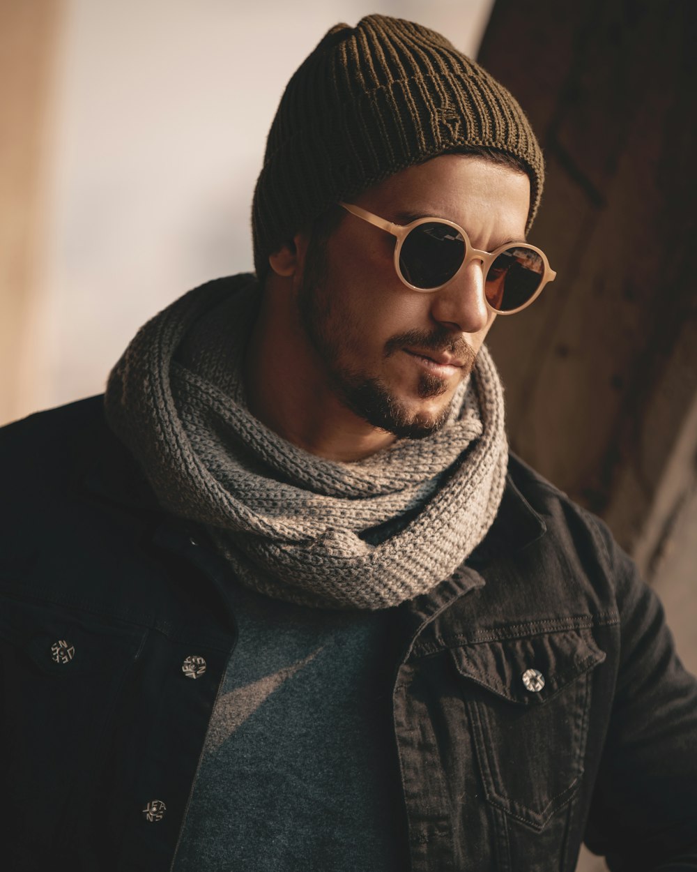 woman in black jacket wearing white knit scarf and black sunglasses