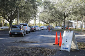 A friendly technician setting up a mobile drug testing station inside a company parking lot.