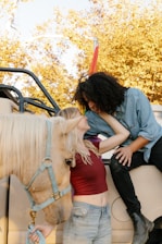 man and woman sitting on white horse during daytime