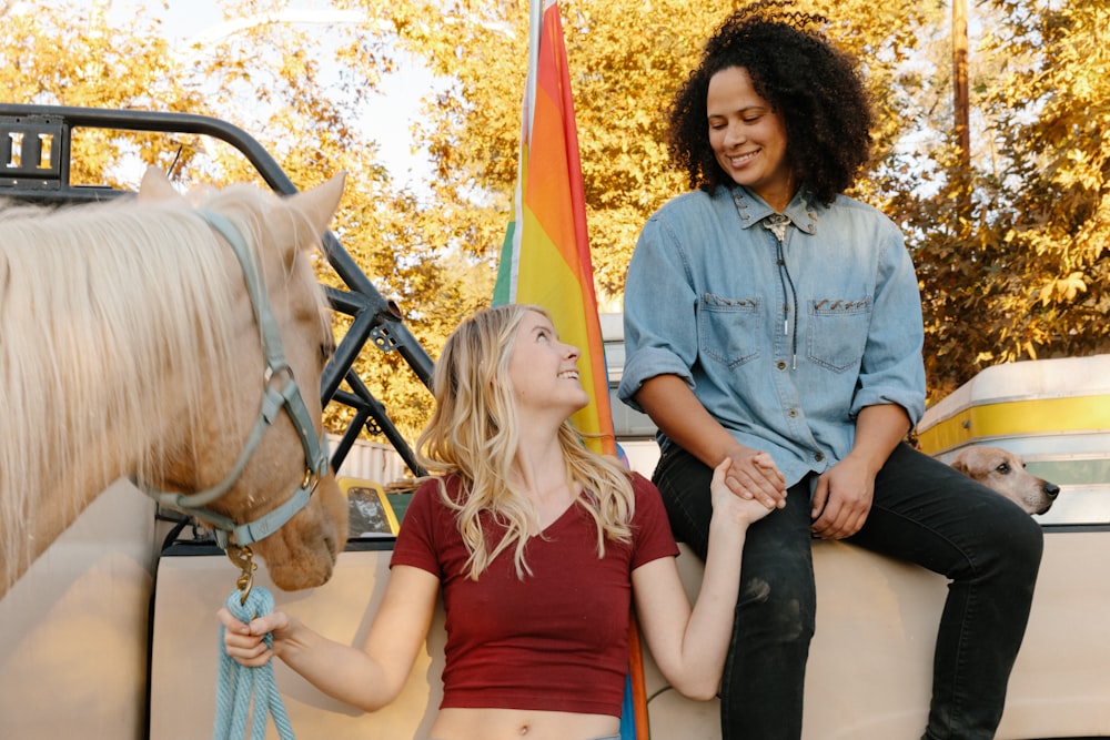 2 femmes assises sur un cheval noir et brun