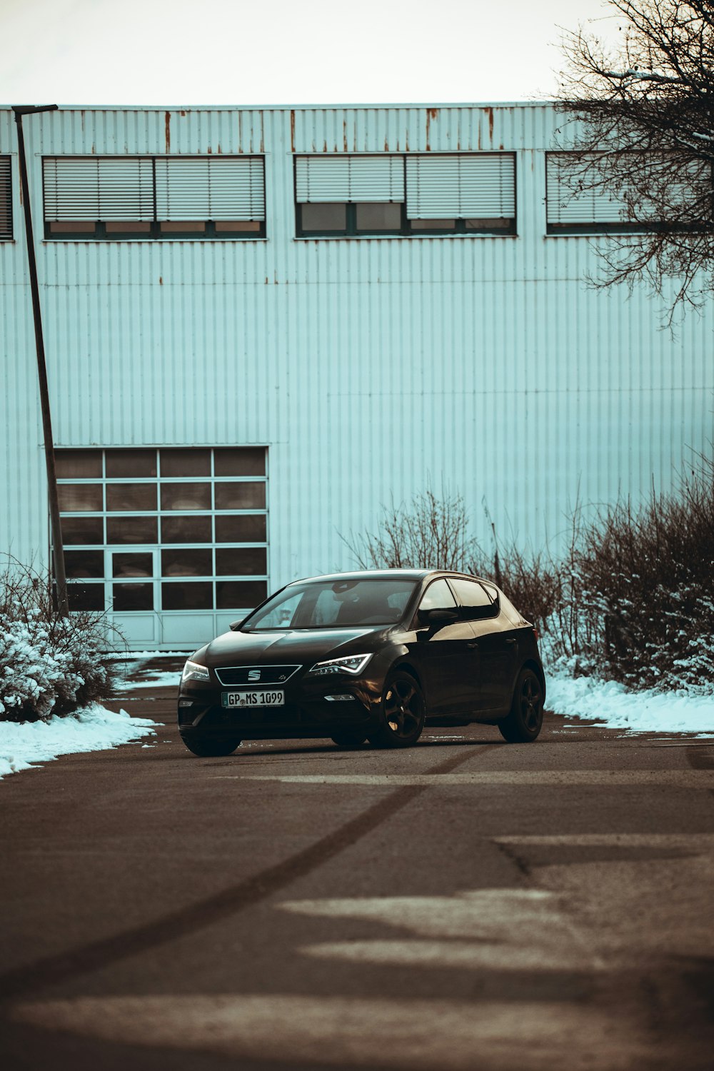 black sedan parked near white building during daytime