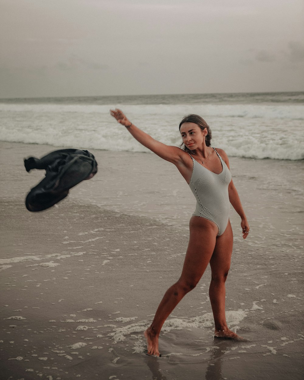 woman in white one piece swimsuit standing on beach during daytime