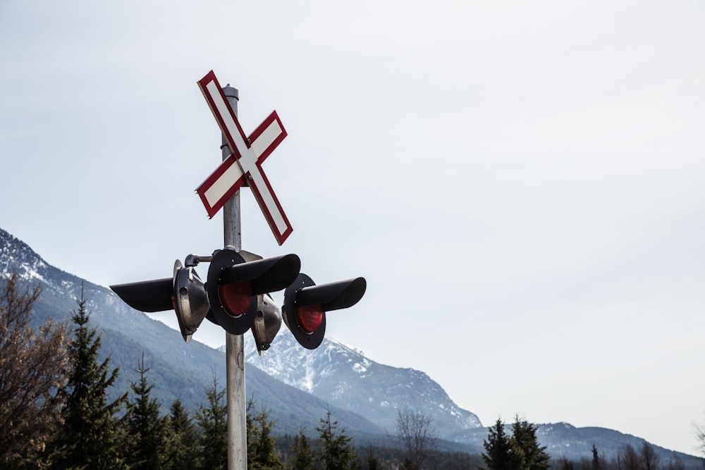 croce rossa e nera in cima alla montagna durante il giorno