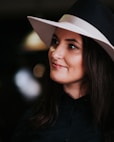 woman in black button up shirt wearing white fedora hat