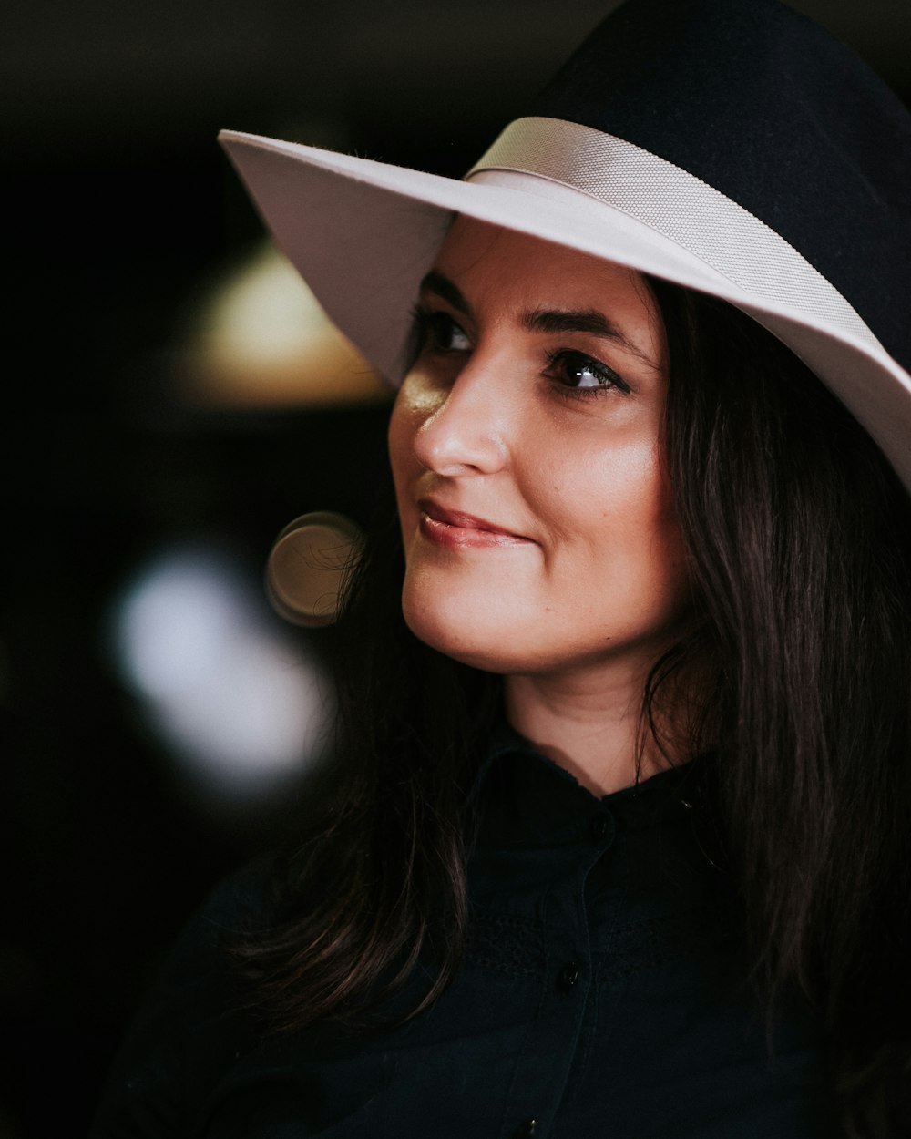 woman in black button up shirt wearing white fedora hat